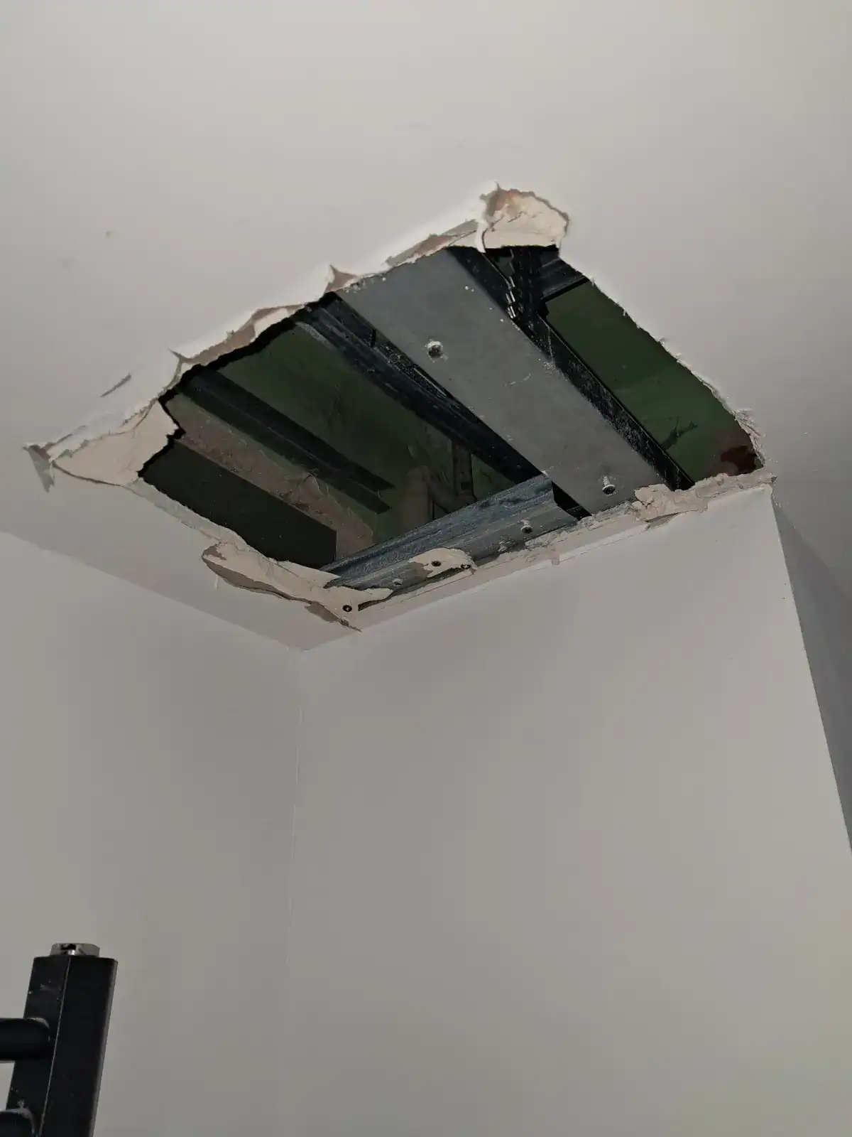Otwór w suficie podwieszanym wykonany w celu naprawy przecieku instalacji CO